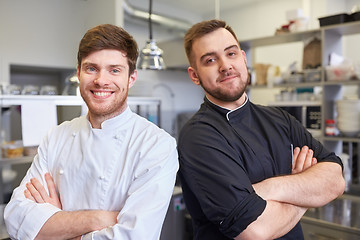 Image showing happy smiling chef and cook at restaurant kitchen