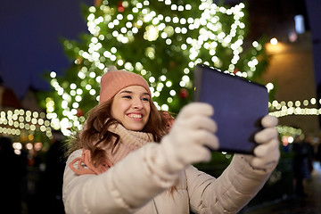 Image showing woman with tablet pc at christmas tree outdoors