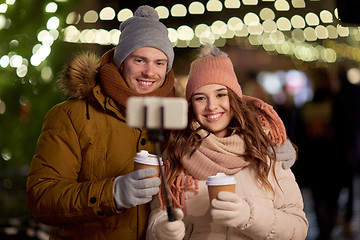 Image showing couple with coffee taking selfie at christmas