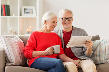 Image showing happy senior couple reading newspaper at christmas