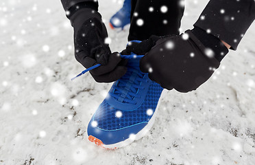 Image showing close up of man tying shoe lace in winter outdoors