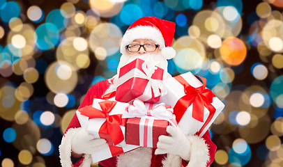 Image showing santa claus with christmas gifts over lights