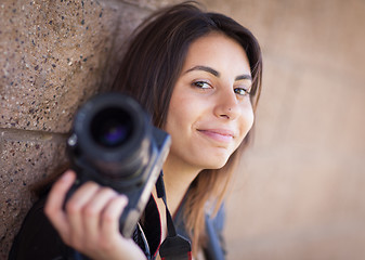 Image showing Young Adult Ethnic Female Photographer Against Wall Holding Came