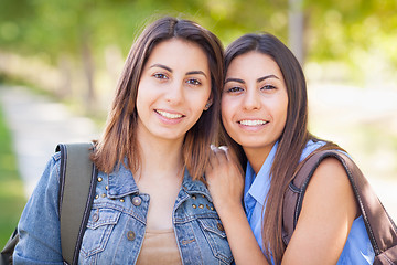 Image showing Two Beautiful Young Ethnic Twin Sisters With Backpacks Walking O