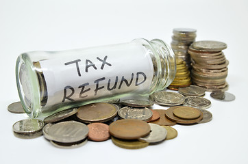 Image showing Tax refund lable in a glass jar with coins spilling out