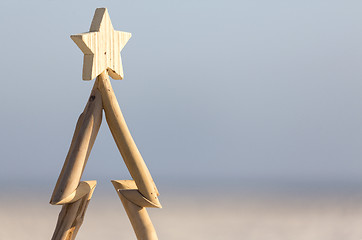 Image showing Wooden Christmas tree against beach background