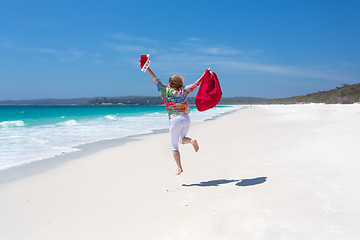 Image showing Celebrate Christmas in Australia - female jumping for joy on bea