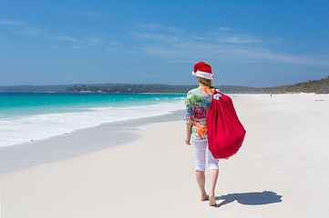 Image showing Christmas in Australia - woman walking along beach with festive 