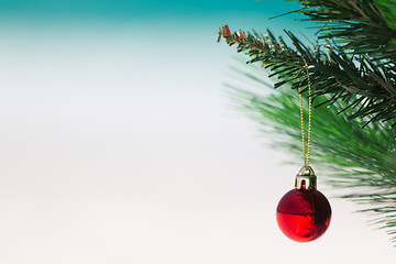Image showing Christmas tree and red bauble at beach close up