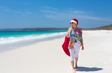 Image showing Christmas down on the beach summer sun female walking with santa