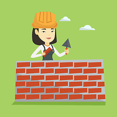 Image showing Bricklayer working with spatula and brick.