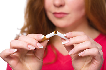 Image showing Young woman is breaking a cigarette