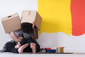 Image showing young multiethnic couple playing with cardboard boxes