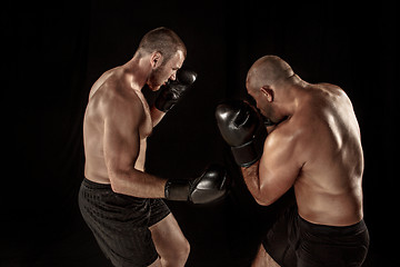 Image showing Two muscular men fighting, bodybuilders punching each other, training in martial arts, boxing, jiu jitsu