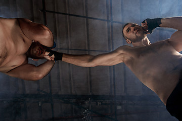 Image showing Two muscular men fighting, bodybuilders punching each other, training in martial arts, boxing, jiu jitsu