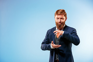 Image showing Portrait of a business man isolated on blue background.