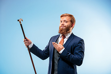 Image showing Tattooed bearded man in a suit holding cane.