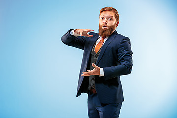 Image showing Portrait of a business man isolated on blue background.