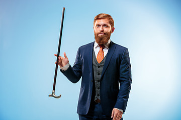 Image showing Tattooed bearded man in a suit holding cane.