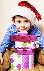 Image showing little cute boy with Christmas gifts at home. close up emotional