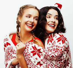 Image showing young pretty happy smiling blond and brunette woman girlfriends on christmas in santas red hat and holiday decorated plaid, lifestyle people concept