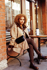 Image showing young pretty african american women drinking coffee outside in c