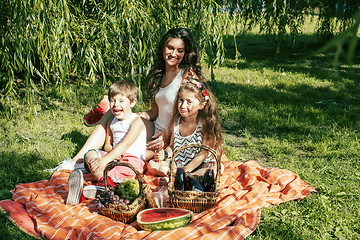 Image showing cute happy family on picnic laying on green grass mother and kid