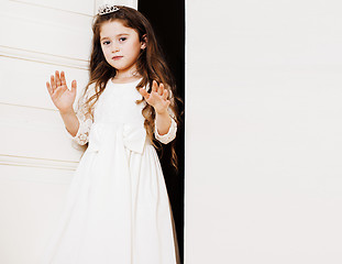 Image showing little cute girl at home, opening door well-dressed in white dre