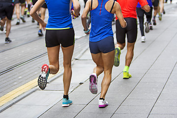 Image showing Marathon runners race in city streets, blurred motion