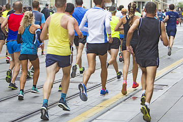 Image showing Marathon runners race in city streets, blurred motion