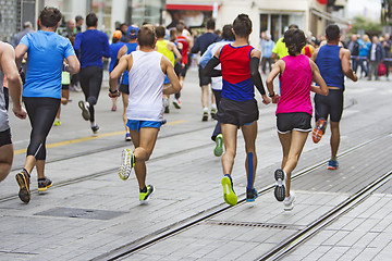 Image showing Marathon runners race in city streets, blurred motion