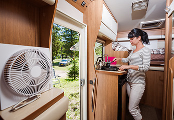 Image showing Woman cooking in camper, motorhome RV interior