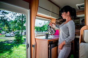 Image showing Woman cooking in camper, motorhome interior RV