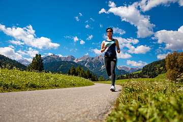 Image showing Woman jogging outdoors. Italy Dolomites Alps