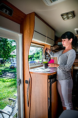 Image showing Woman cooking in camper, motorhome interior RV