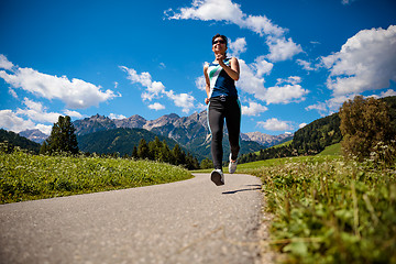 Image showing Woman jogging outdoors. Italy Dolomites Alps