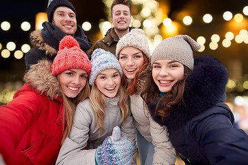 Image showing happy friends taking selfie outdoors at christmas