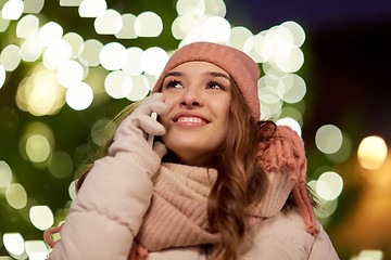 Image showing happy woman calling on smartphone at christmas