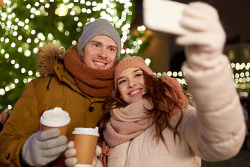 Image showing couple with coffee taking selfie at christmas