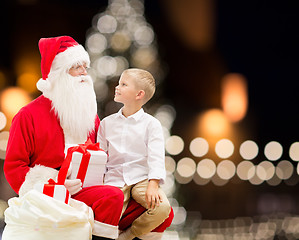 Image showing santa claus and happy boy with christmas gift