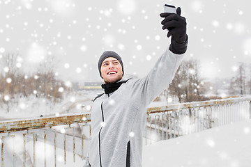 Image showing man taking selfie with smartphone in winter 