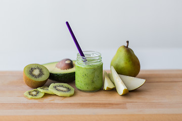 Image showing jar with fruit puree or baby food on wooden board