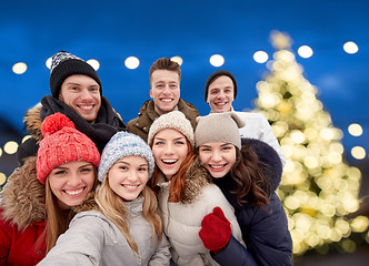 Image showing happy friends taking selfie outdoors at christmas