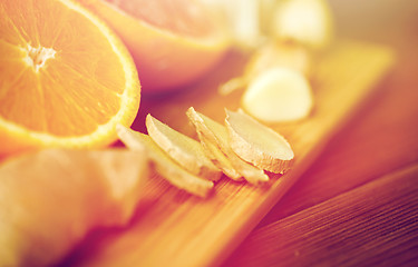 Image showing ginger, garlic and orange on wooden board