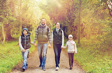 Image showing happy family with backpacks hiking in woods