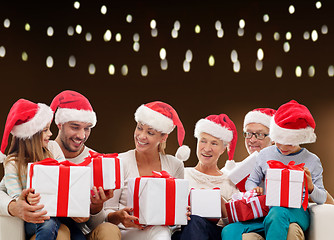 Image showing happy family in santa hats with christmas gifts