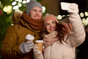 Image showing couple with coffee taking selfie at christmas