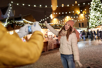 Image showing happy woman posing for smartphone at christmas