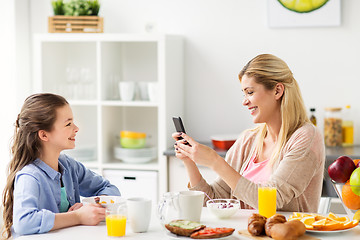 Image showing family with smartphone having breakfast at home