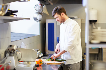 Image showing happy male chef cooking food at restaurant kitchen